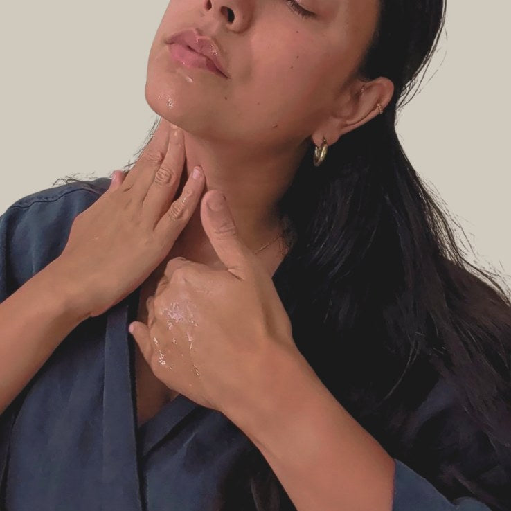 Woman applying liminal elixirs cleansing oil to their neck