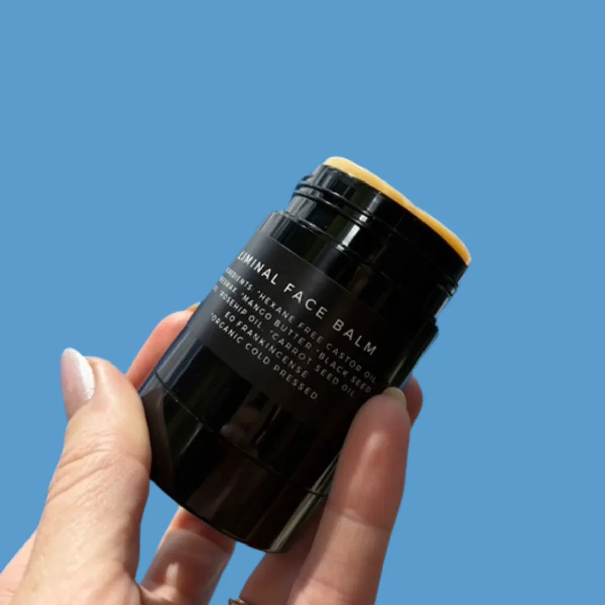 Hand holding face balm stick