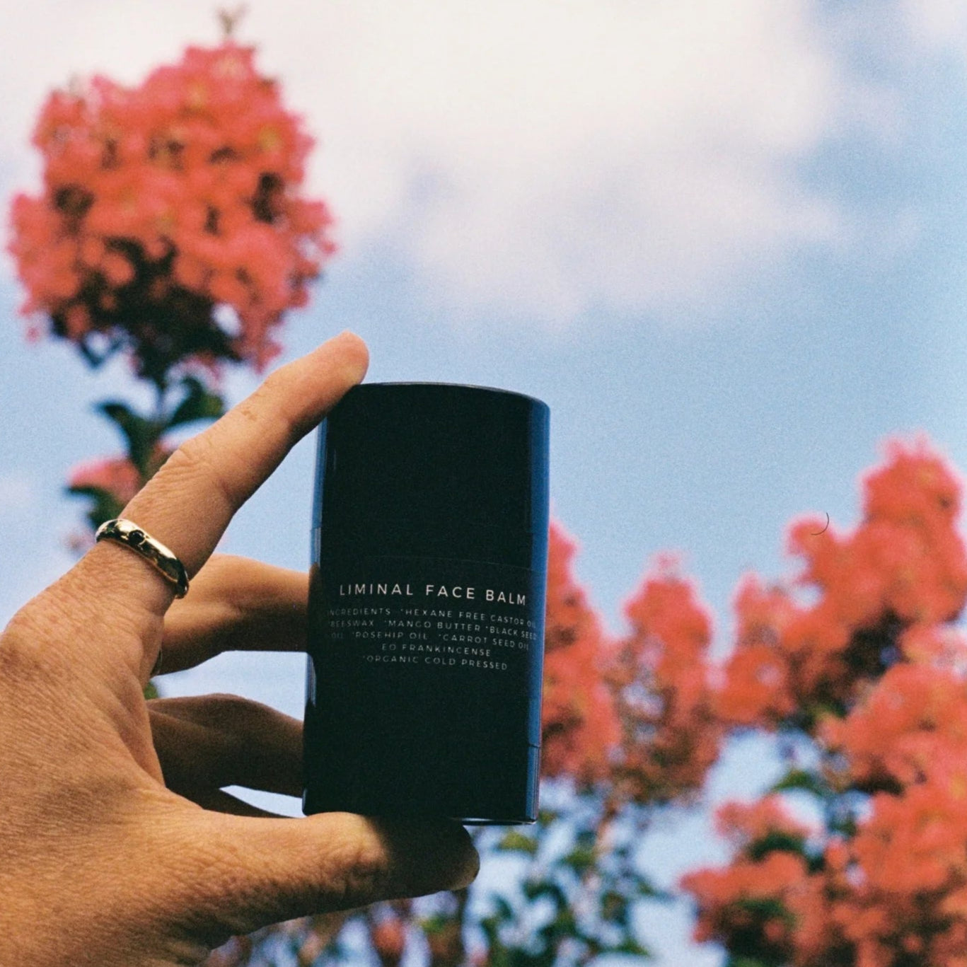 Hand holding a black container labeled &