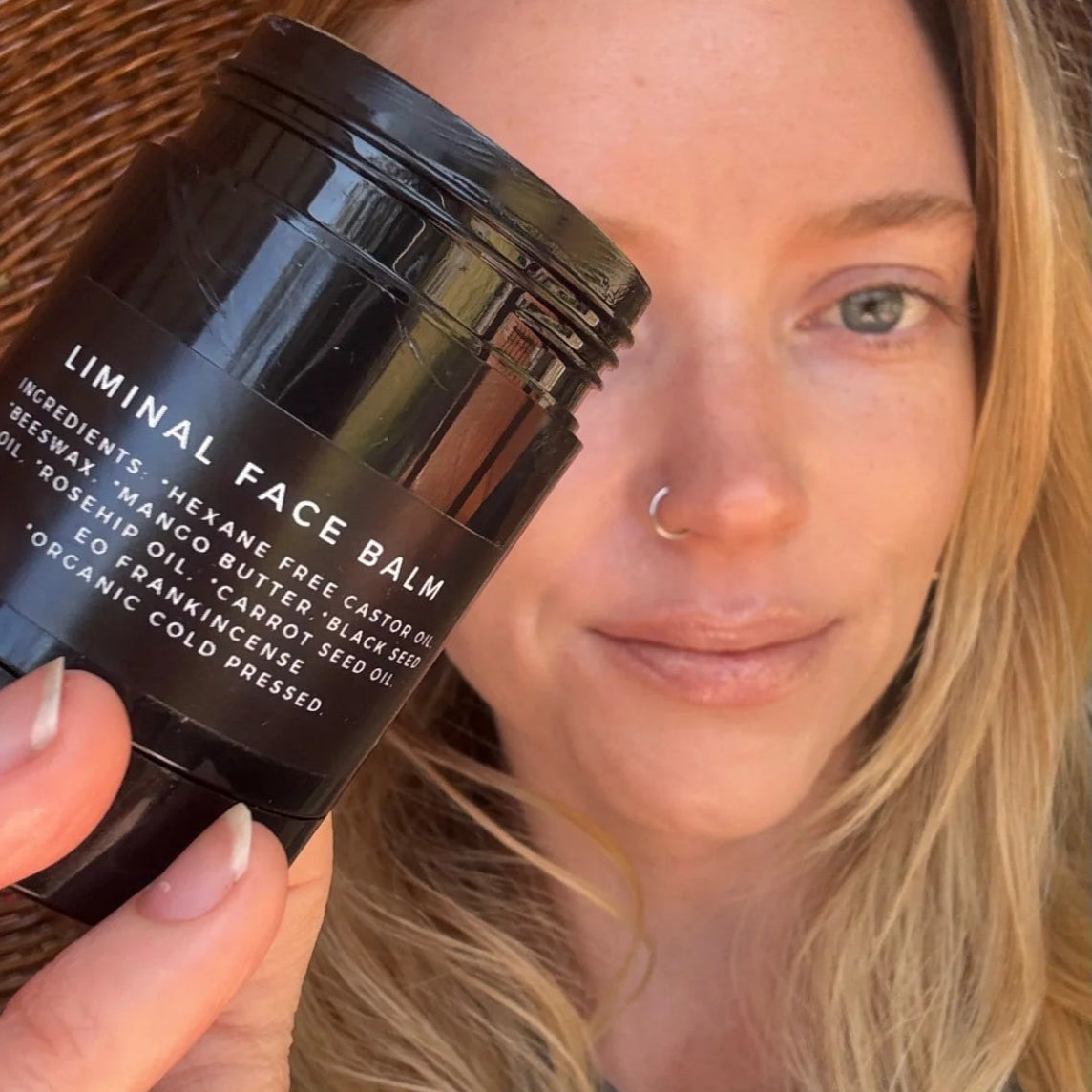 Person holding a black container labeled &