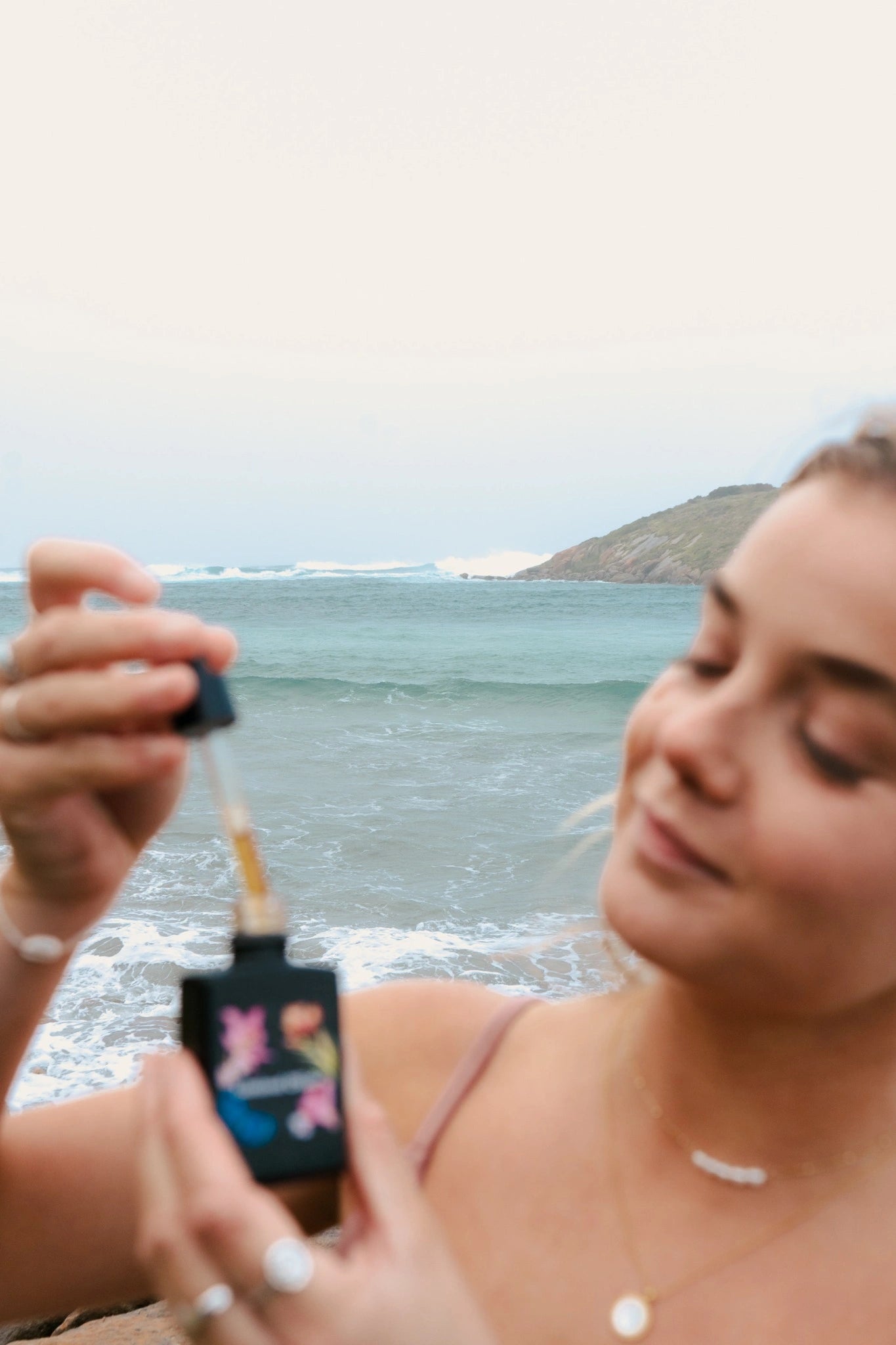 Woman applying skincare outdoors with a scenic background