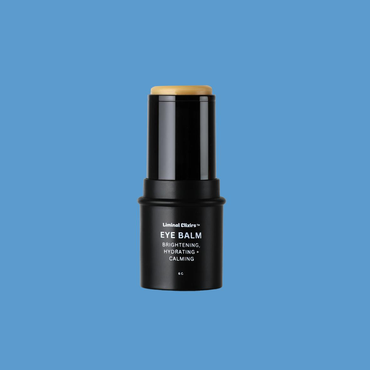 Black Liminal Elixirs eye balm stick on a blue background
