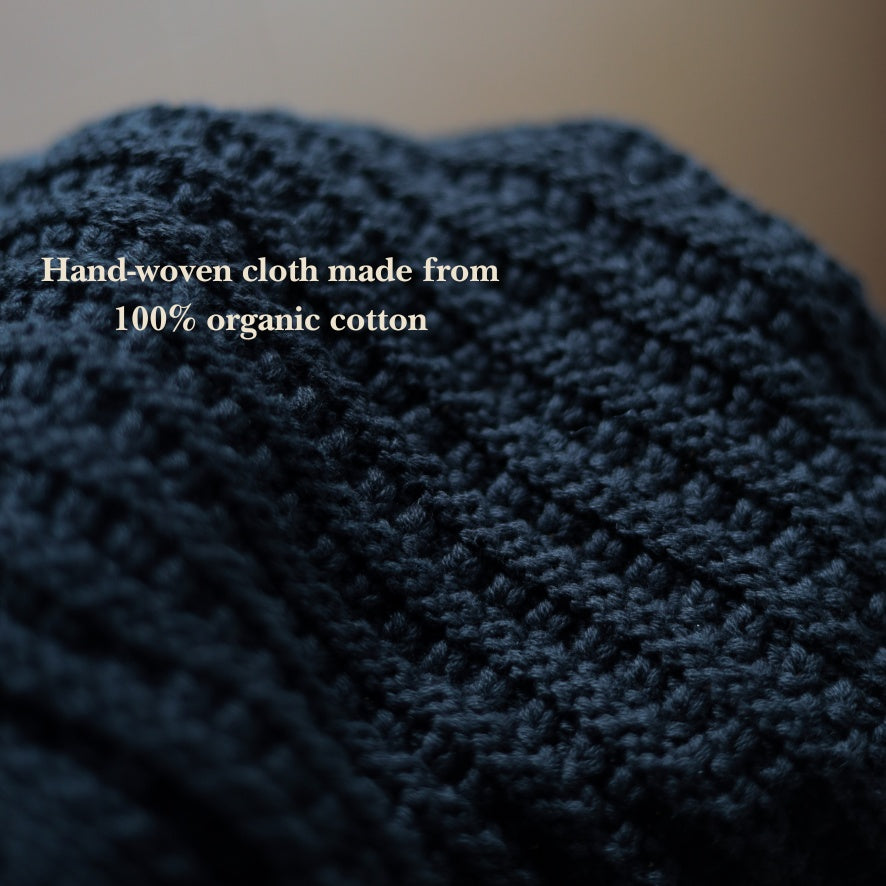Hand-woven blue fabric made from 100% organic cotton with text overlay.
