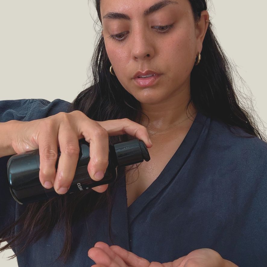 Woman applying Cleansing Elixir Oil during her Liminal skincare ritual
